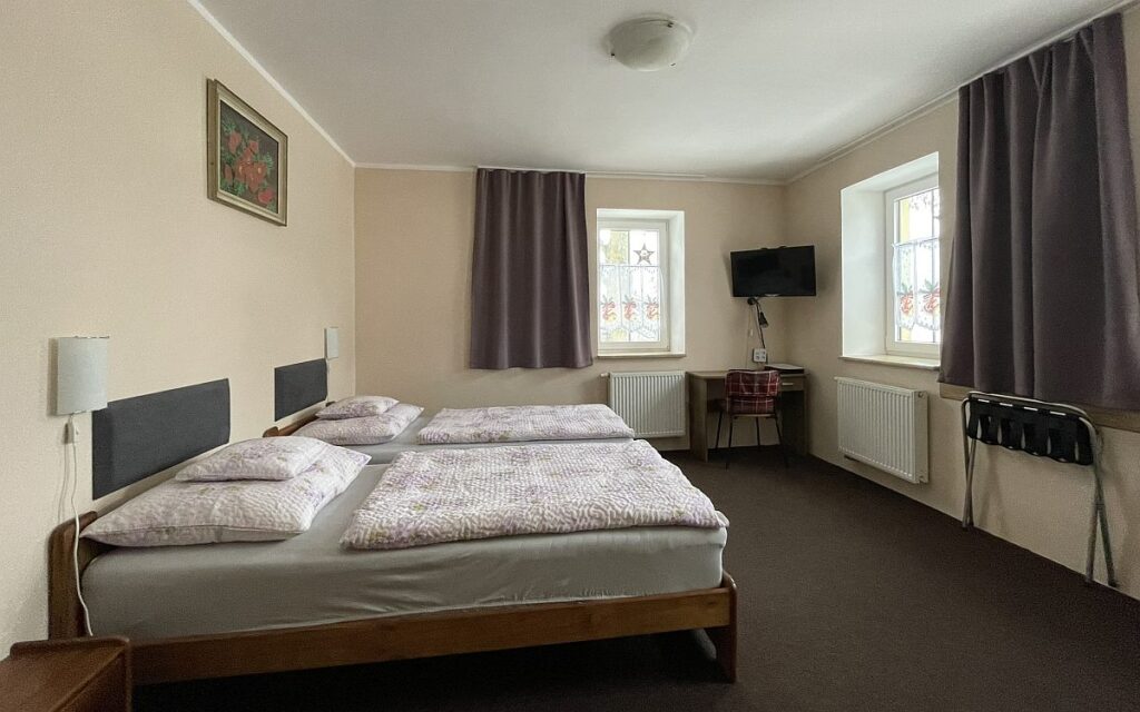 pohled na pokoj z boku , pracovní stolek a televize - ubytování se stravováním